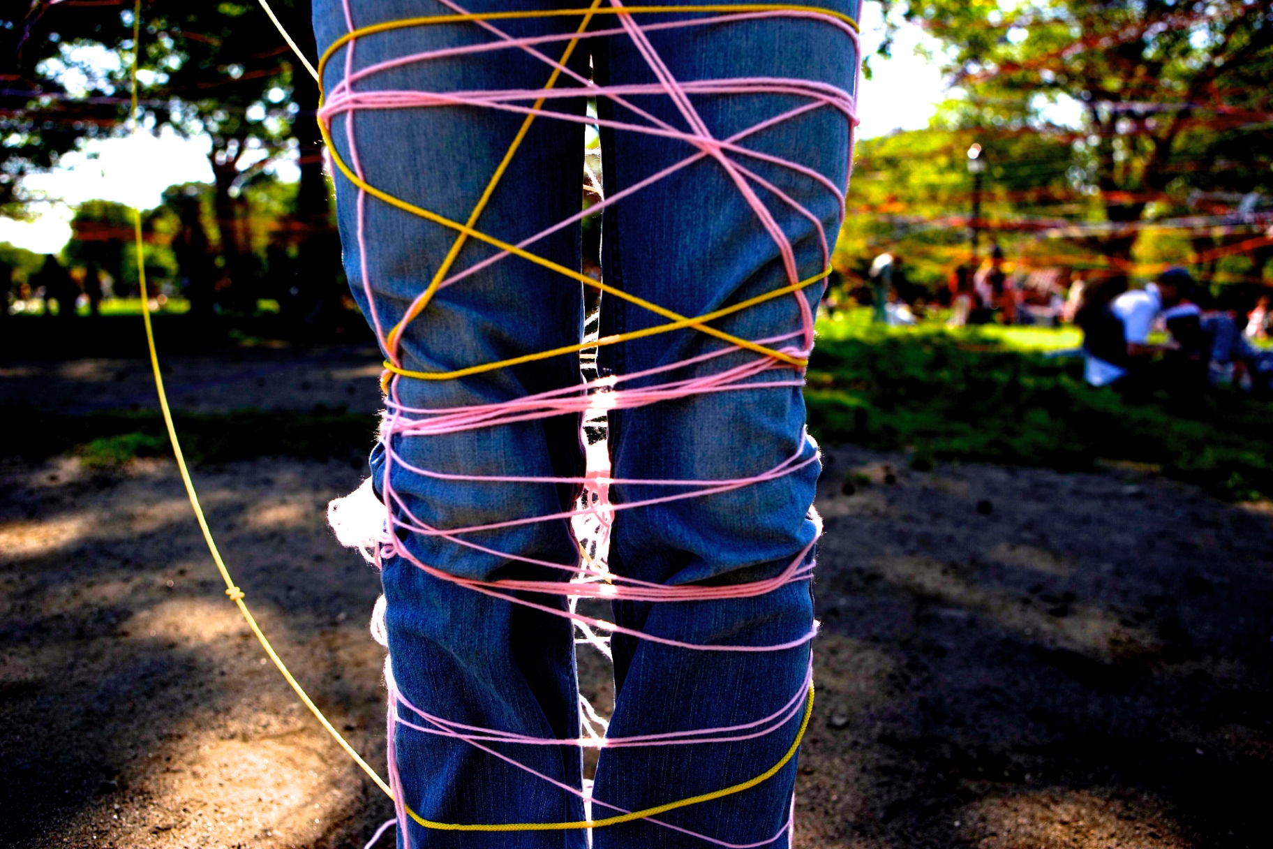 Legs wrapped in pink and yellow string