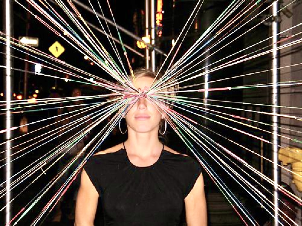 Portrait of Jasmine Zimmerman at the center of a radiating rainbow string web