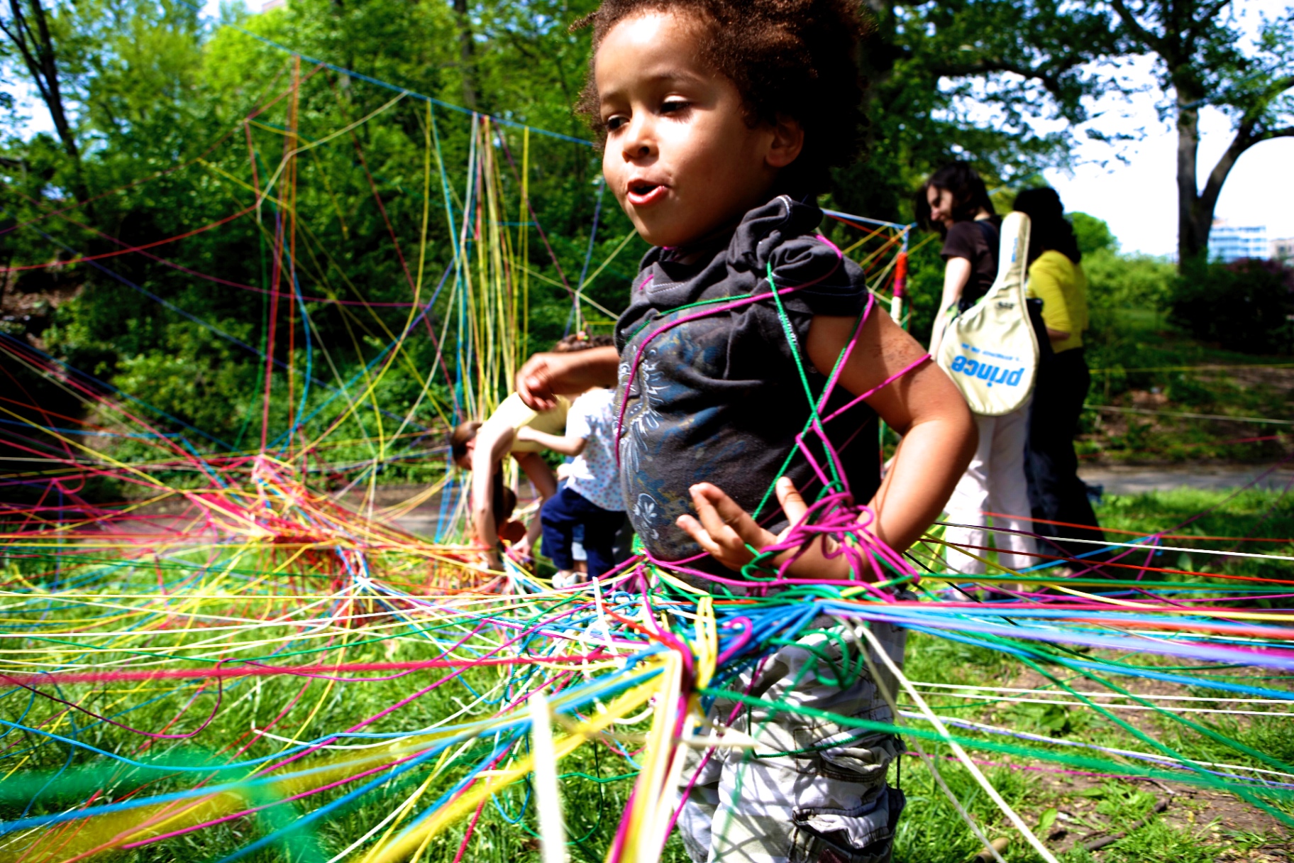 Child running joyfully through the string installation